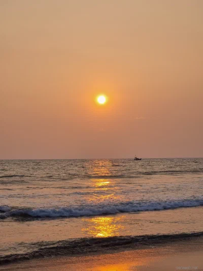 The setting sun reflected in waves at the beach