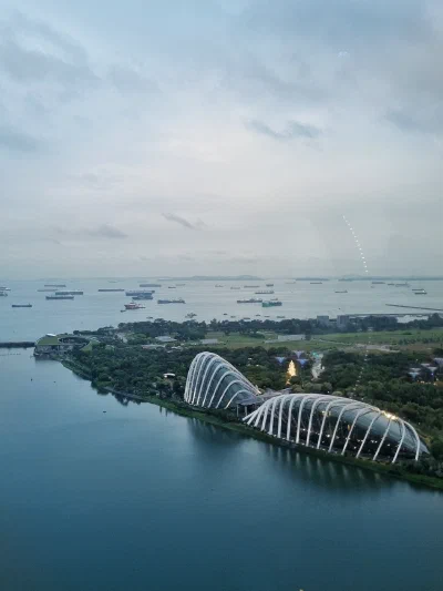 Gardens and conservatories beside the water beneath a cloudy sky